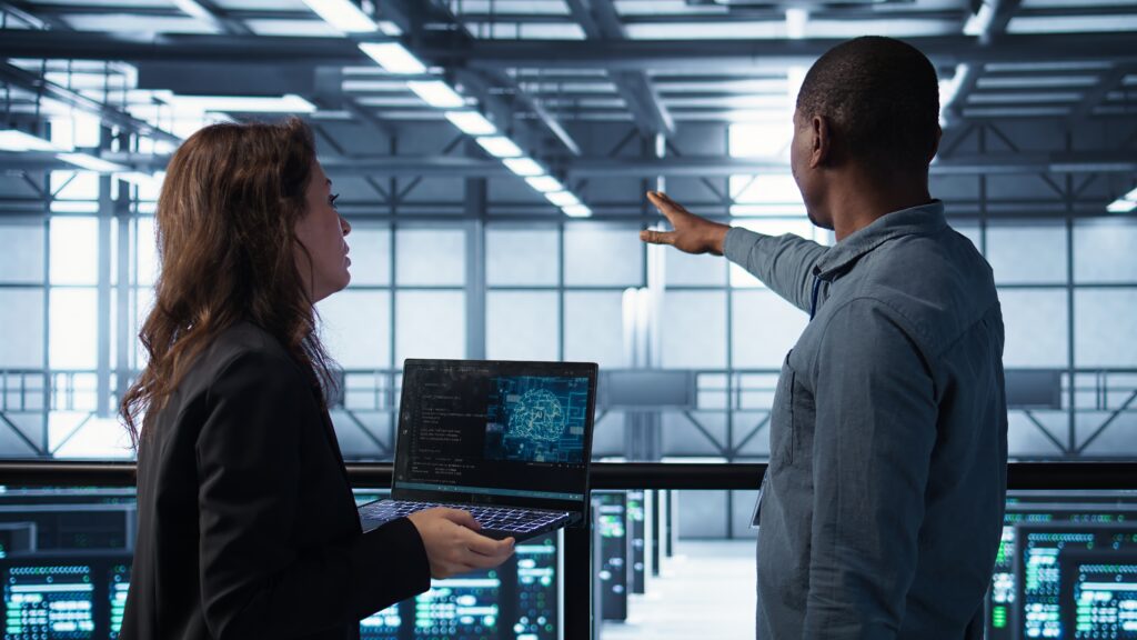 programmers coding on laptop using artificial intelligence in server farm programmers coding on laptop using artificial intelligence in server farm